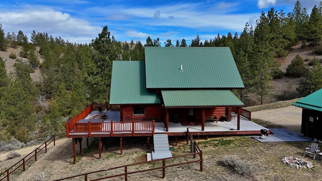 3340 Rome Ln, Stevensville, MT 59870 - back of house with log siding, a deck, a wooded view, and metal roof