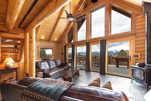 3340 Rome Ln, Stevensville, MT 59870 - living room with a wood stove, high vaulted ceiling, log walls, wooden ceiling with exposed beams, and a mountain view