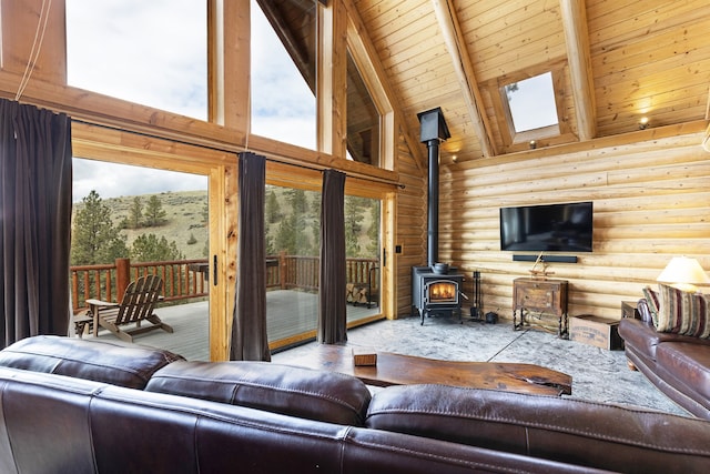 3340 Rome Ln, Stevensville, MT 59870 - living area with high vaulted ceiling, log walls, a wood stove, and wood ceiling with exposed beams