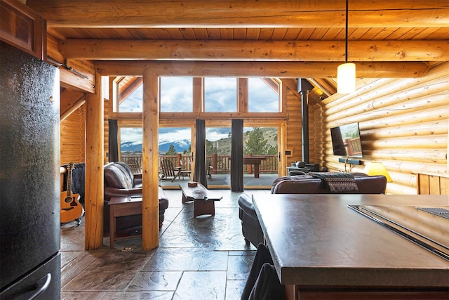 3340 Rome Ln, Stevensville, MT 59870 - living room featuring log walls, a wood stove, wood ceiling with exposed beams, and stone tile flooring