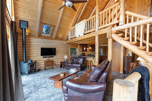 3340 Rome Ln, Stevensville, MT 59870 - carpeted living area with high vaulted ceiling, wood ceiling with exposed beams, a ceiling fan, rustic walls, and a wood stove