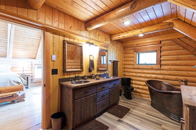 3340 Rome Ln, Stevensville, MT 59870 - bathroom with wooden ceiling with exposed beams, wood finished floors, a soaking tub, double vanity, and rustic walls