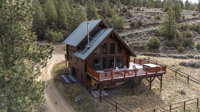 3340 Rome Ln, Stevensville, MT 59870 - back of house with a wooden deck, log siding, metal roof, and a wooded view