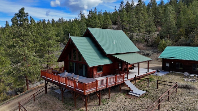 3340 Rome Ln, Stevensville, MT 59870 - back of property with a wooded view, a wooden deck, metal roof, and log exterior