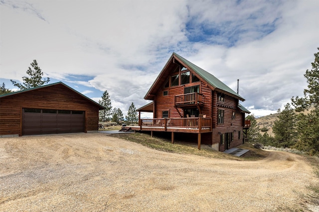 3340 Rome Ln, Stevensville, MT 59870 - log cabin with a balcony, a garage, driveway, an outdoor structure, and metal roof
