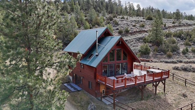 3340 Rome Ln, Stevensville, MT 59870 - rear view of house with a wooden deck and metal roof