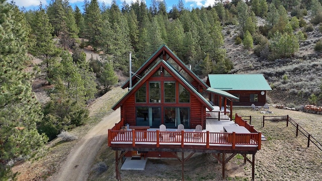 3340 Rome Ln, Stevensville, MT 59870 - back of house featuring a deck, a forest view, and log exterior