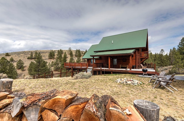 3340 Rome Ln, Stevensville, MT 59870 - rear view of house with a deck with mountain view, log siding, and metal roof