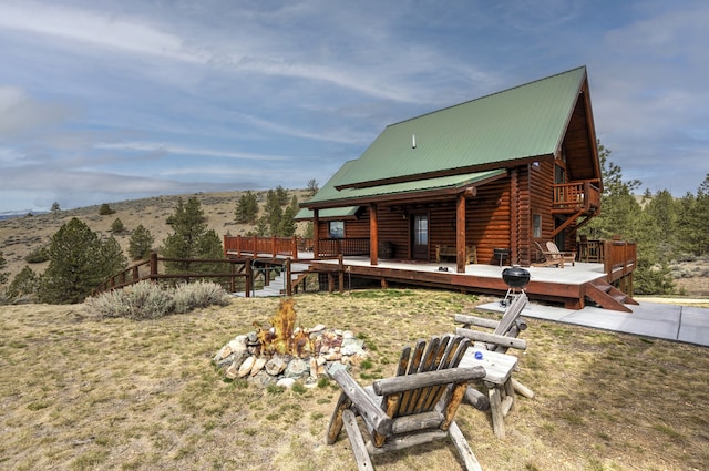 3340 Rome Ln, Stevensville, MT 59870 - rear view of property featuring a deck, metal roof, and log veneer siding