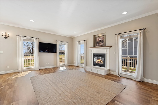 266 W Bowman Dr, Kalispell, MT 59901 - unfurnished living room featuring light wood-style flooring, a glass covered fireplace, baseboards, recessed lighting, and ornamental molding