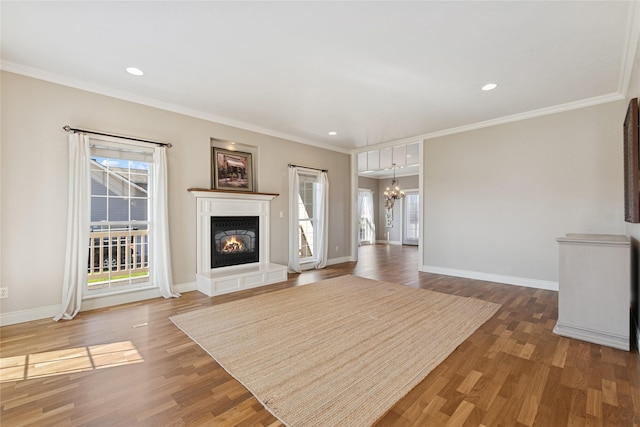 266 W Bowman Dr, Kalispell, MT 59901 - unfurnished living room with wood finished floors, ornamental molding, baseboards, a glass covered fireplace, and a notable chandelier