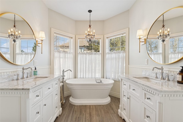 266 W Bowman Dr, Kalispell, MT 59901 - bathroom featuring wainscoting, a notable chandelier, wood finished floors, and a sink
