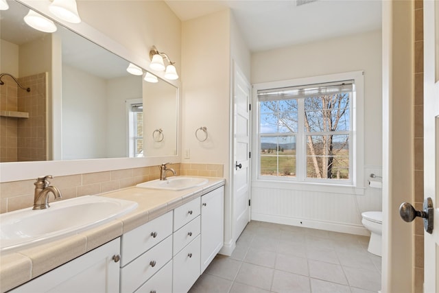 266 W Bowman Dr, Kalispell, MT 59901 - bathroom featuring wainscoting, toilet, tile patterned floors, and a sink