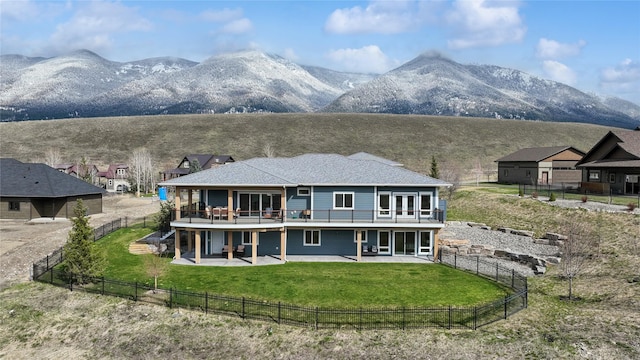 back of house featuring a fenced backyard, a yard, a deck with mountain view, and a patio