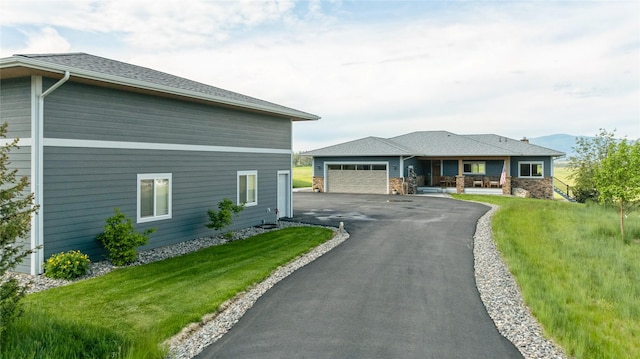 160 Quirk Trl, Eureka, MT 59917 - view of front of home featuring asphalt driveway, a front lawn, a porch, and a garage