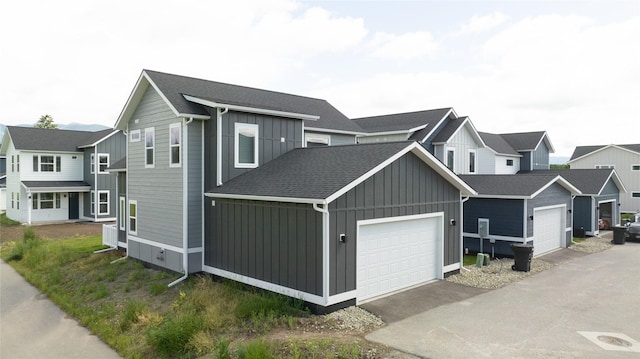 402 Trailview Way, Whitefish, MT 59937 - view of front of house with board and batten siding, a garage, a shingled roof, and a residential view