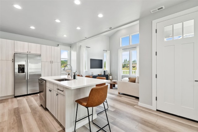 402 Trailview Way, Whitefish, MT 59937 - kitchen with stainless steel appliances, recessed lighting, light wood-style floors, a breakfast bar, and light countertops