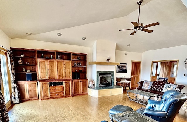 93 Golf Course Dr, Ennis, MT 59729 - living room featuring light wood-type flooring, a tiled fireplace, a ceiling fan, and high vaulted ceiling