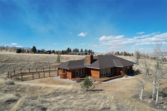 93 Golf Course Dr, Ennis, MT 59729 - view of side of property featuring covered porch, a chimney, french doors, a shingled roof, and a view of countryside