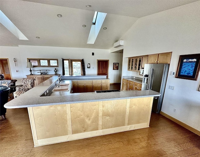93 Golf Course Dr, Ennis, MT 59729 - kitchen with a skylight, appliances with stainless steel finishes, a large island with sink, glass insert cabinets, and wood finished floors