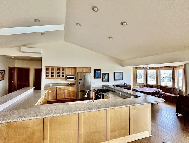 93 Golf Course Dr, Ennis, MT 59729 - kitchen featuring high end refrigerator, built in microwave, glass insert cabinets, a wall unit AC, and brown cabinets