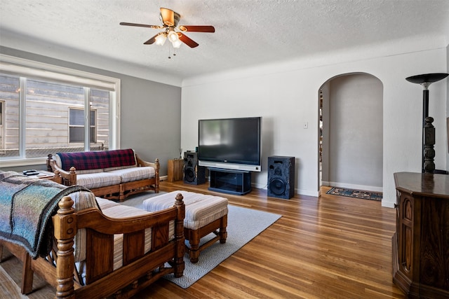 620 Stephens Ave, Missoula, MT 59801 - living area featuring arched walkways, ceiling fan, a textured ceiling, wood finished floors, and baseboards