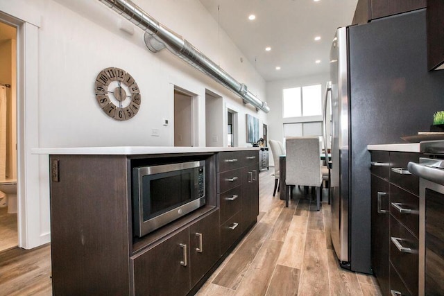 21D Hickory Loop, Whitefish, MT 59937 - kitchen with stainless steel appliances, light wood-style floors, recessed lighting, dark brown cabinets, and light countertops