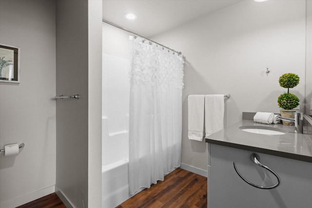 bathroom featuring baseboards, vanity, wood finished floors, and shower / bath combination with curtain