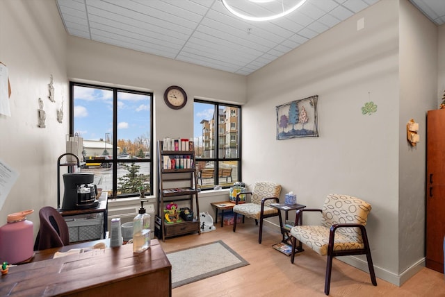 office space with baseboards, plenty of natural light, and wood finished floors