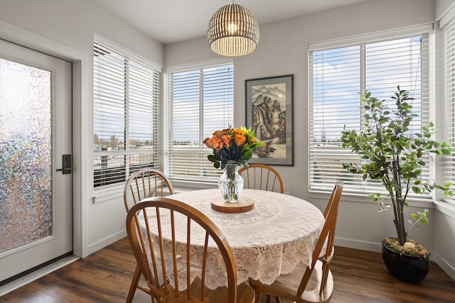 dining room with a wealth of natural light, a notable chandelier, and dark wood-style floors