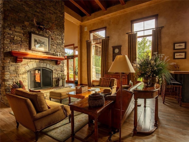 6104 Monterra Ave Unit L, Whitefish, MT 59937 - living area with beam ceiling, a towering ceiling, wood-type flooring, and a stone fireplace