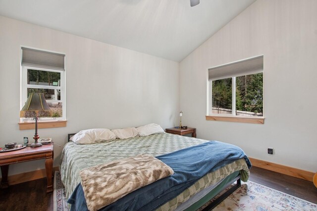 bedroom with baseboards, vaulted ceiling, a ceiling fan, and wood finished floors