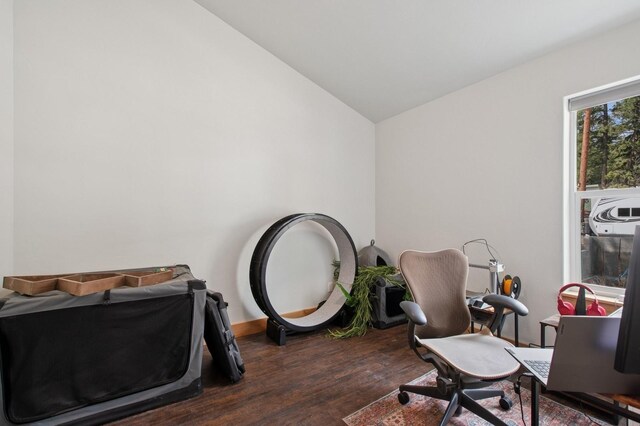 spare room featuring dark wood-style flooring, baseboards, vaulted ceiling, and visible vents