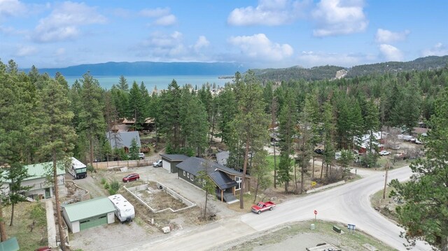 birds eye view of property with a view of trees and a water view