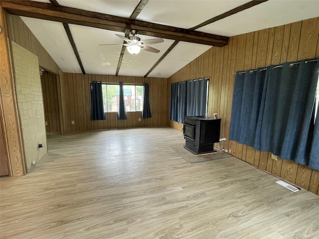 381 Lyng Ave W, Highwood, MT 59450 - unfurnished living room featuring light wood-type flooring, wood walls, a wood stove, and ceiling fan