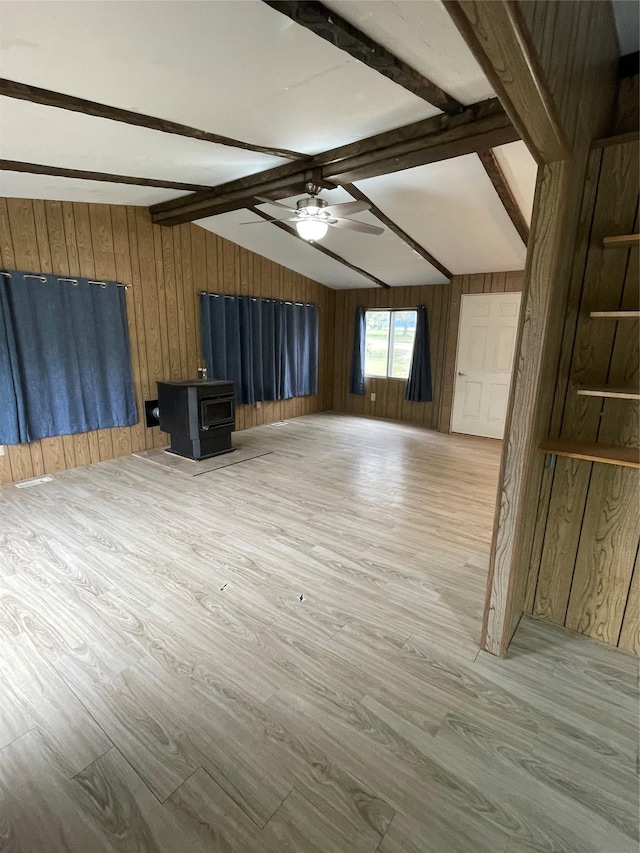 381 Lyng Ave W, Highwood, MT 59450 - unfurnished living room with a wood stove, wooden walls, ceiling fan, and wood finished floors