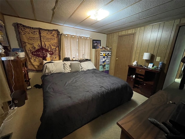 carpeted bedroom featuring visible vents and wooden walls