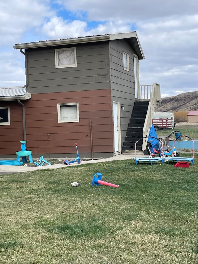 exterior space featuring stairs and a yard