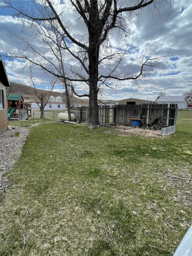view of yard featuring fence and a playground