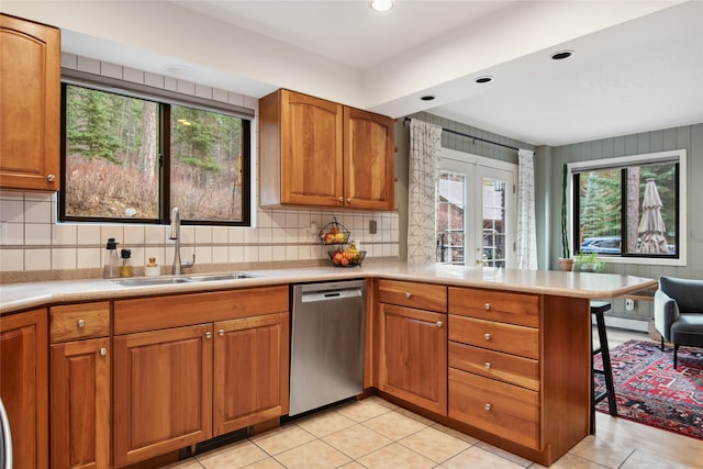 kitchen featuring stainless steel dishwasher, a peninsula, a sink, healthy amount of natural light, and recessed lighting
