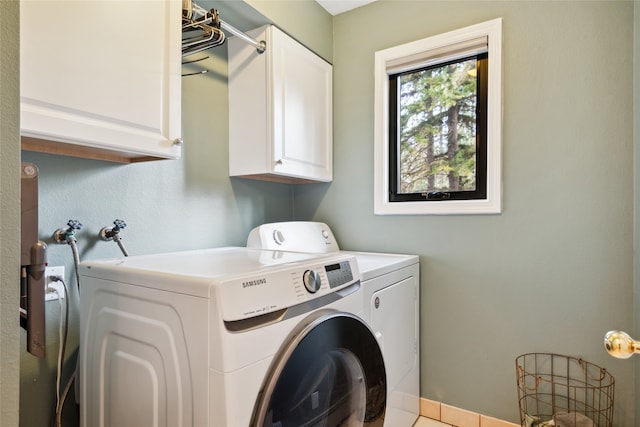 washroom featuring cabinet space and washer and clothes dryer