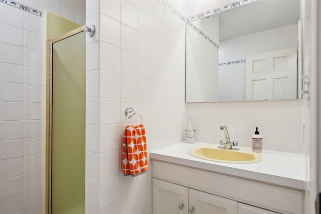 full bath featuring tile walls, vanity, decorative backsplash, and a shower stall