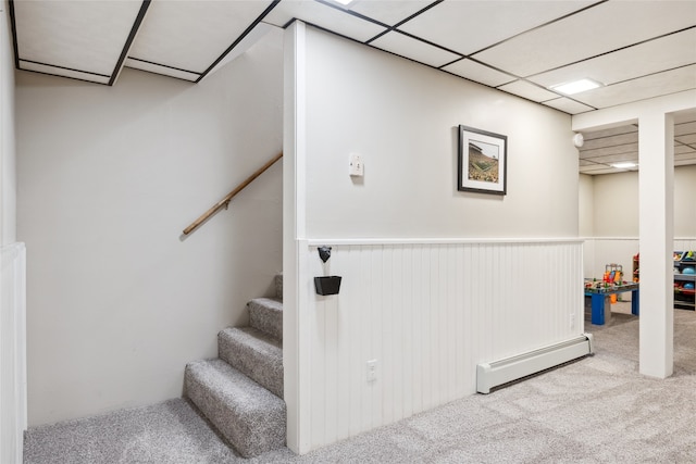 stairway featuring baseboard heating, carpet flooring, and wainscoting