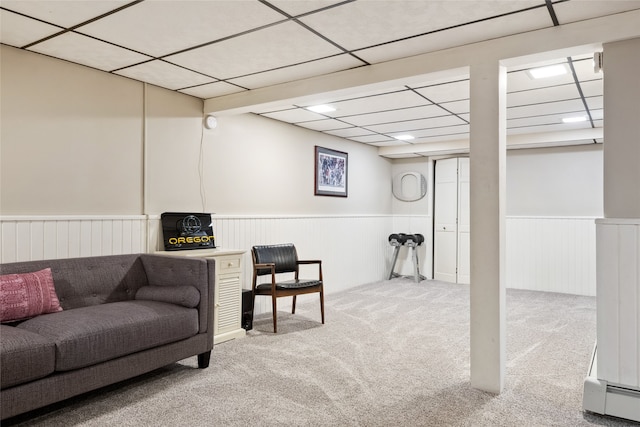 carpeted living area featuring wainscoting and a paneled ceiling