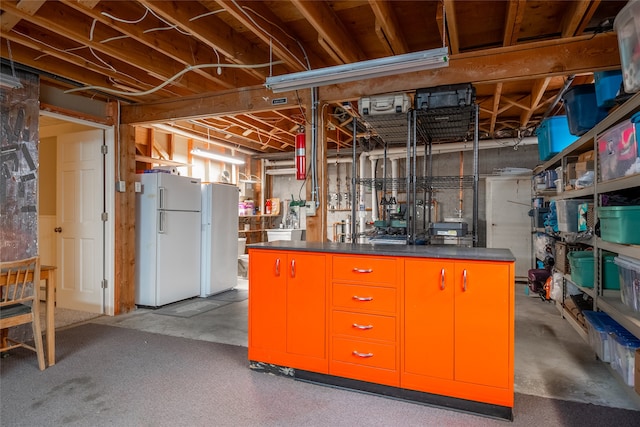 unfinished basement featuring freestanding refrigerator