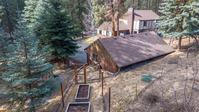 aerial view of property and surrounding area featuring a forest