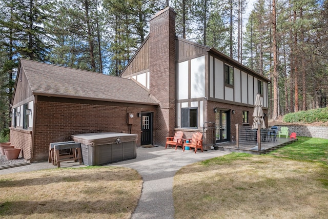 view of front facade featuring a hot tub, brick siding, a chimney, and roof with shingles