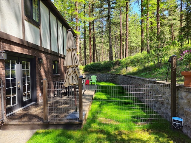 view of yard featuring french doors and fence