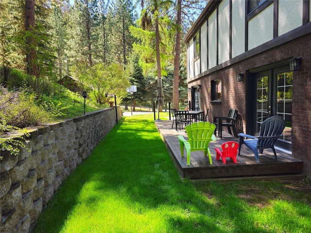 view of grassy yard with a deck