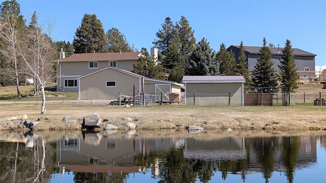 rear view of property featuring fence and a water view